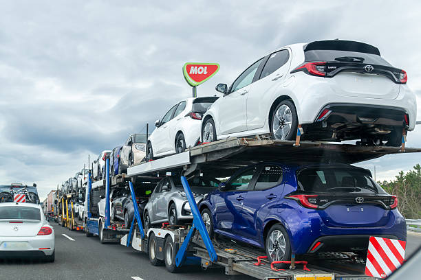 Multi-level car carrier trailer loaded with new vehicles traveling on highway